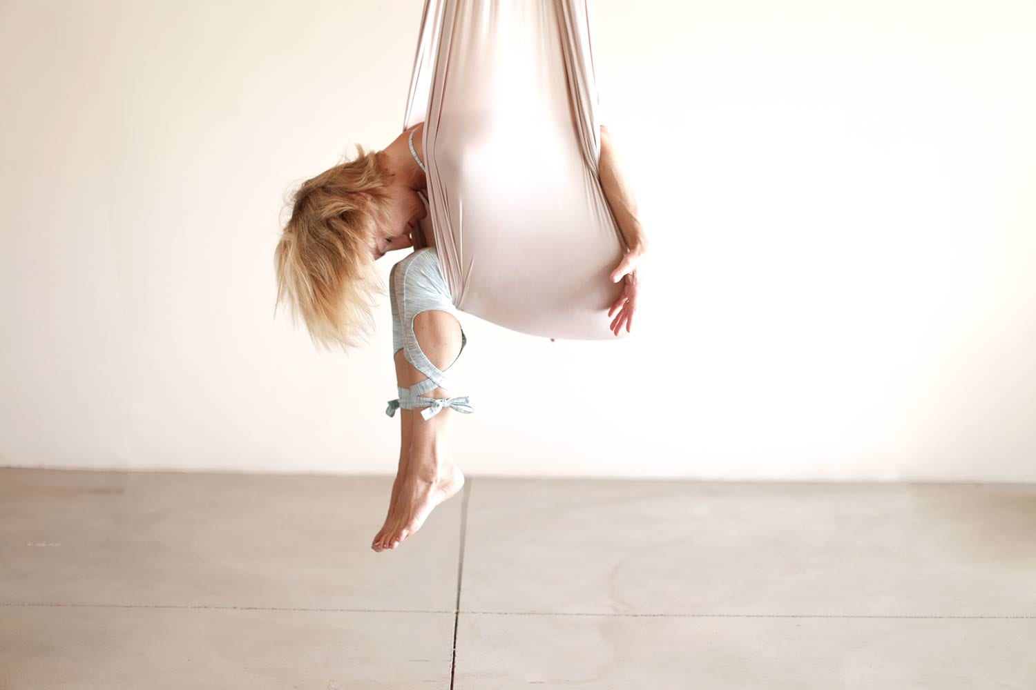 Founder Carmen Curtis in Hammock doing restorative aerial yoga pose